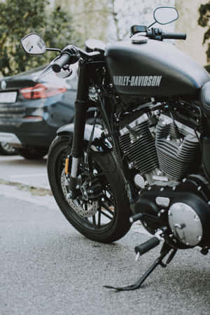 A Man Cruises On His Cruiser-style Hd Motorcycle In The Mountains Wallpaper
