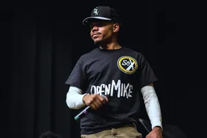 A Man In A Black Shirt Standing On Stage Wallpaper
