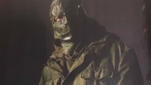 A Man In A Green Jacket And A Mask Wallpaper