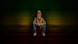 A Man In A Hat Sitting On The Ground Wallpaper