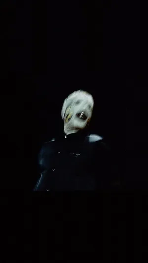 A Man In A Mask Is Standing In The Dark Wallpaper