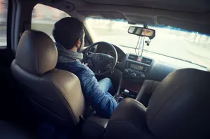 A Man Is Driving A Car With His Hands On The Steering Wheel Wallpaper