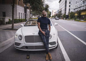 A Man Is Leaning On A Bentley Continental Wallpaper