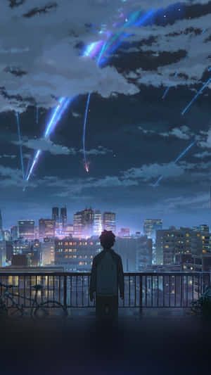 A Man Is Looking Out Over A City At Night Wallpaper