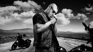 A Man Is Smoking A Cigarette On A Motorcycle Wallpaper