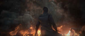 A Man Is Standing In Front Of A Fire Wallpaper