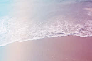 A Man Is Standing On A Beach With A Surfboard Wallpaper