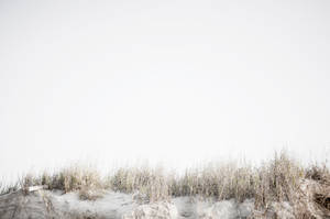 A Man Is Standing On A Sand Dune Wallpaper