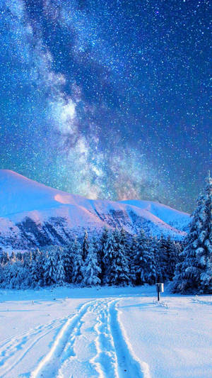 A Man Is Walking Through The Snow Under The Milky Wallpaper