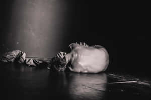 A Man Laying On The Floor With His Head Down Wallpaper