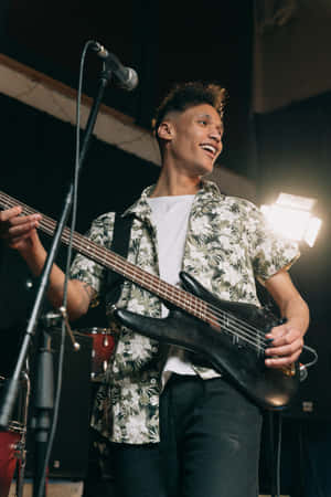 A Man Playing A Guitar In A Recording Studio Wallpaper