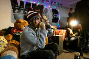 A Man Sitting On A Couch With A Teddy Bear Wallpaper