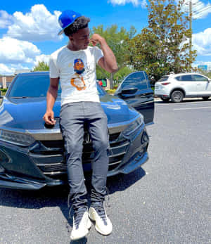 A Man Sitting On The Side Of A Black Car Wallpaper