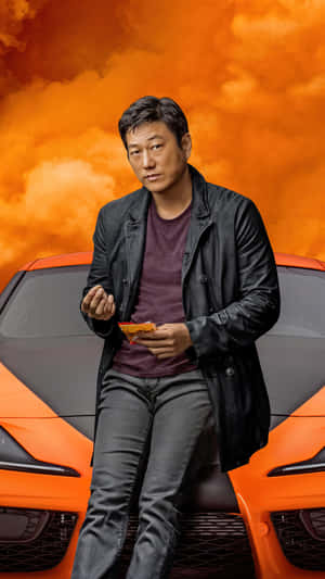 A Man Sitting On Top Of A Sports Car Wallpaper