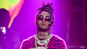A Man With Dreadlocks And A Necklace On Stage Wallpaper