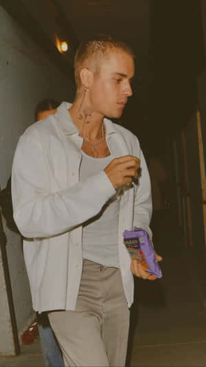 A Man With Tattoos Walking Down The Street Wallpaper