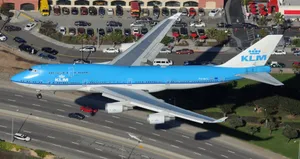 A Massive Boeing 747 Flying High Over The Landscape Wallpaper