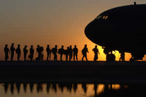 A Military Plane Soars Across The Sky Wallpaper