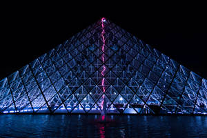A Modern-day Grand Spectacle Of Paris—the Louvre Museum At Night Wallpaper