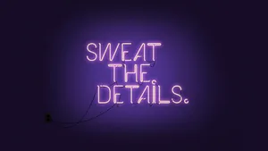 A Neon Sign That Says Sweat The Details Wallpaper