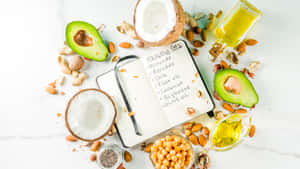 A Notebook With Avocado, Nuts, And Other Ingredients Wallpaper