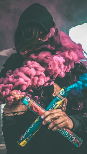A Person Holding A Pink And Blue Smoke Wallpaper