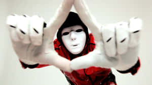 A Person In A Red Mask Making A Hand Gesture Wallpaper