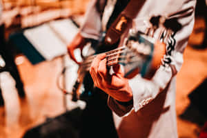 A Person Playing A Bass Guitar In A Concert Wallpaper