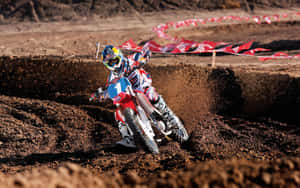 A Person Riding A Dirt Bike On A Dirt Track Wallpaper