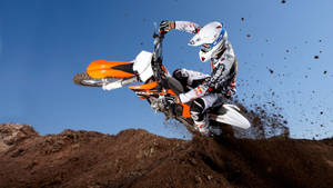 A Person Riding A Dirt Bike On A Dirt Track Wallpaper