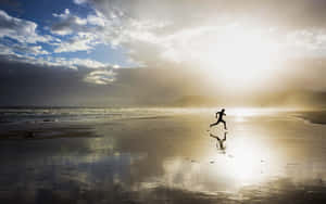A Person Running On The Beach Wallpaper