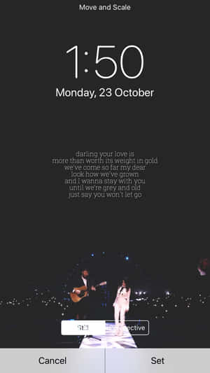 A Phone Screen Showing A Concert And A Clock Wallpaper