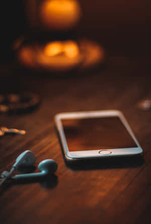 A Phone With Headphones On A Table Wallpaper