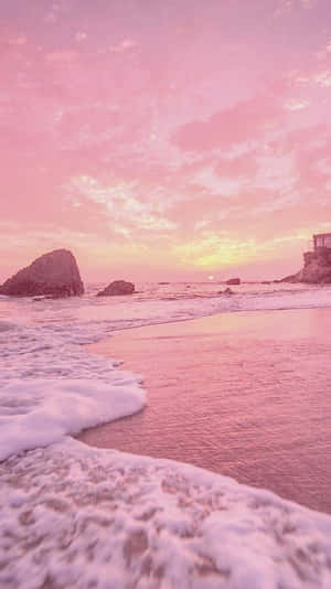 A Pink Sunset With Waves On The Beach Wallpaper