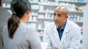 A Professional Pharmacist Consulting With A Customer Wallpaper