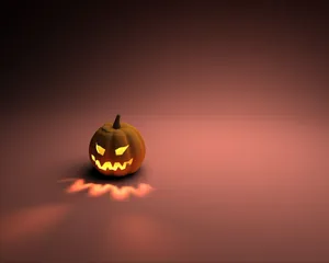 A Pumpkin Is Lit Up On A Dark Background Wallpaper