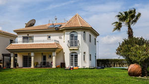 A Quintessential Display Of A White And Brown Roofed Beautiful House Wallpaper