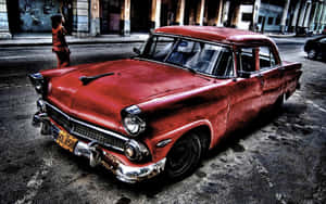 A Red Car Is Parked On The Street In Cuba Wallpaper