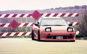 A Red Car Parked In Front Of A Fence Wallpaper