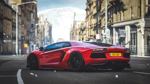 A Red Sports Car Driving Down A City Street Wallpaper