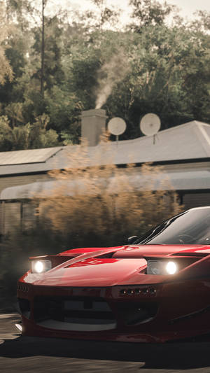 A Red Sports Car Driving Down A Road Wallpaper