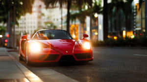 A Red Sports Car Driving Down The Street Wallpaper