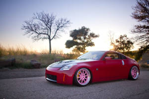 A Red Sports Car Parked In The Middle Of A Field Wallpaper