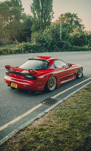 A Red Sports Car Parked On The Side Of The Road Wallpaper