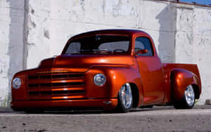 A Red Truck Parked In Front Of A White Wall Wallpaper