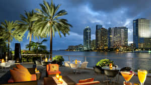 A Restaurant With Tables And Chairs Overlooking The Water Wallpaper