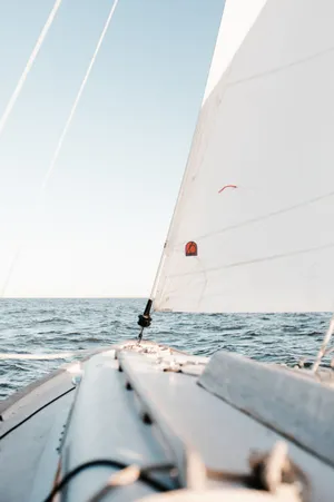 A Sailboat Is Sailing In The Ocean Wallpaper