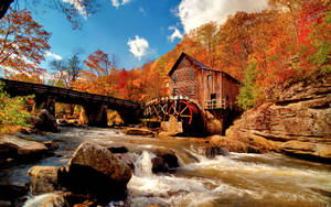 A Scenic Autumn Landscape With River And A Warm House Wallpaper