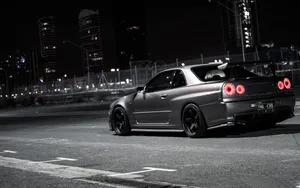 A Silver Car Is Parked On A Street At Night Wallpaper