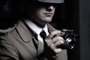 A Skilled Private Detective Capturing Evidence Using A Professional Camera Wallpaper